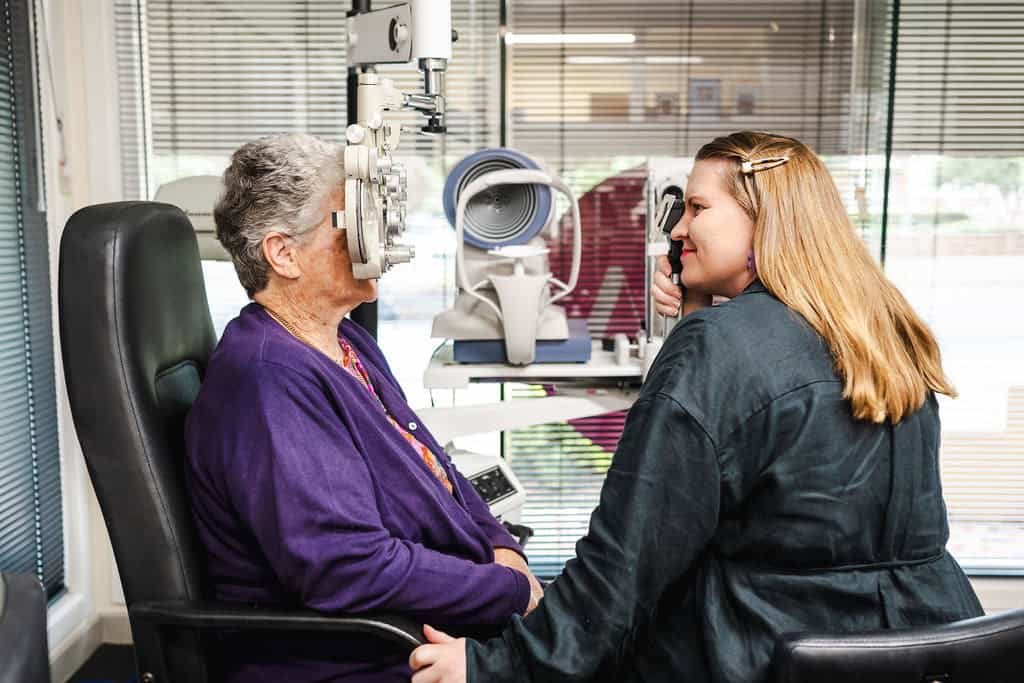 Optometrist Abby Ussher performing an eye exam with a female patient